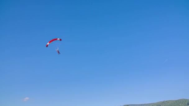 Skydiver Czerwonym Spadochronem Zbliża Się Przygotowuje Lądowania Polu Trawy — Wideo stockowe