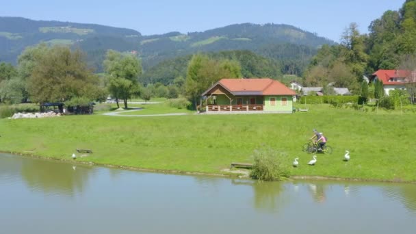 Homem Mulher Casal Andar Bicicleta Uma Margem Lago Com Casas — Vídeo de Stock
