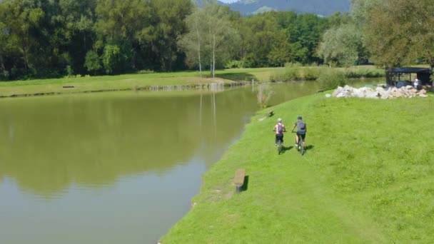 Ζευγάρι Στα Τους Κάνει Ποδήλατο Μια Λίμνη Ένας Άντρας Τραβάει — Αρχείο Βίντεο
