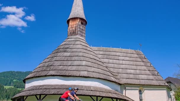 Tilting Shot Revealing Two Bikers Riding Rotunda Saint John Baptist — Stock Video