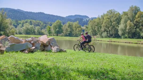 Dos Jóvenes Viajeros Montando Bicicletas Junto Hermoso Lago Eslovenia Movimiento — Vídeos de Stock