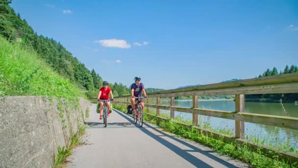 Glückliches Paar Radelt Flussradweg Blauem Himmelstag Grüne Vegetation — Stockvideo