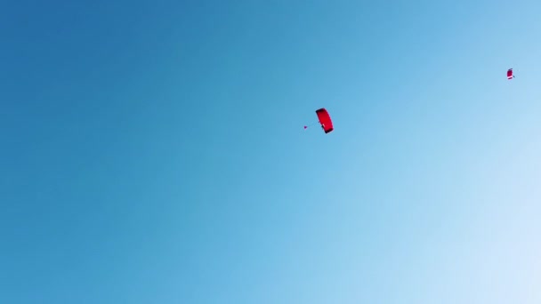 Rode Parachutes Glijden Dalen Langzaam Een Spiraalvormige Beweging Een Heldere — Stockvideo