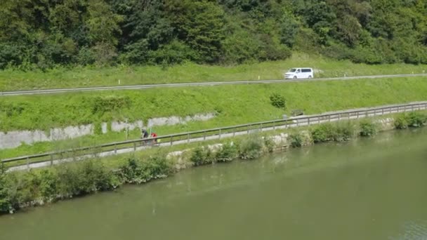 Dua Orang Mengendarai Sepeda Jalur Sepeda Tepi Sungai Dan Jalan — Stok Video