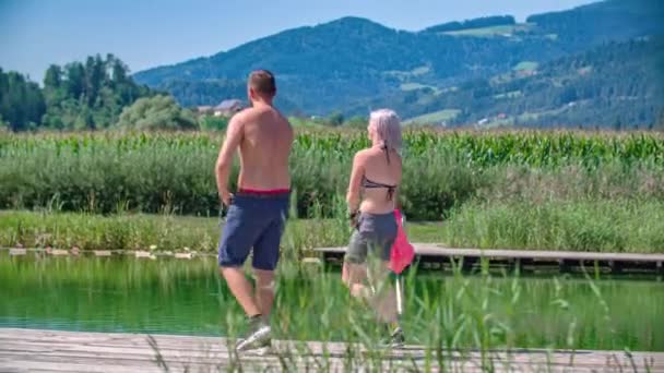 Young Caucasian Couple Run Boardwalk Swimming Take Shirts Change Mind — Stock Video