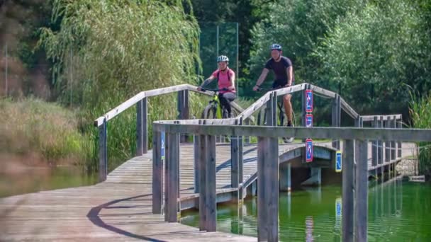 Casal Apto Ciclismo Juntos Caminho Madeira Através Lago Radlje Dravi — Vídeo de Stock