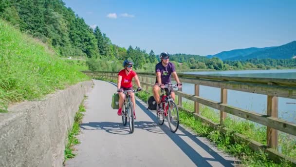 Sporty Couple Enjoys Bike Ride Edge Lake Lush Green Landscape — Stock Video