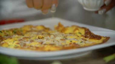 Ocak üzerinde omlet malzemeler koyarak