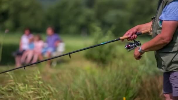 Familie sitzt auf Bank am Teich — Stockvideo