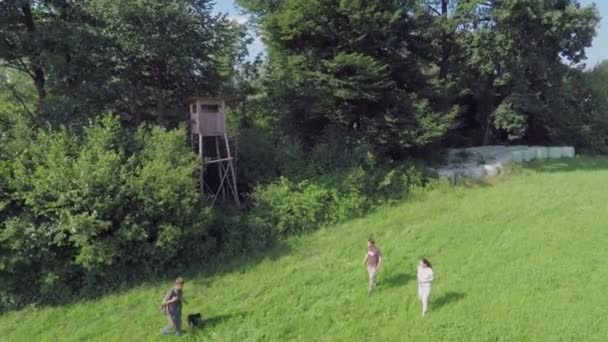 Tre människor gå i en grön gräsmatta — Stockvideo