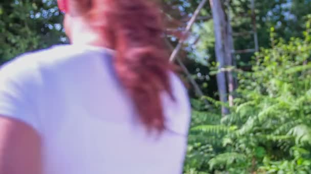 Kvinnan ger blommor till jägare i en grön gräsmatta — Stockvideo