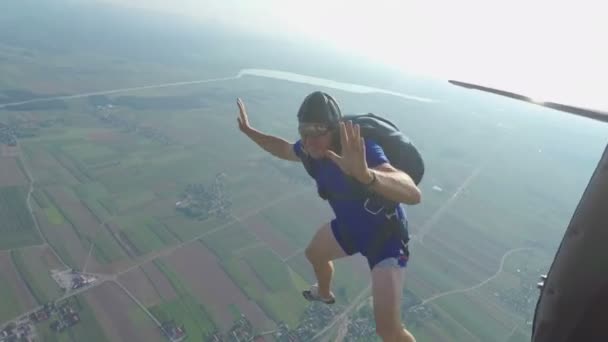 Мужчина, как он ныряет в небо и выпрыгивает из самолета — стоковое видео