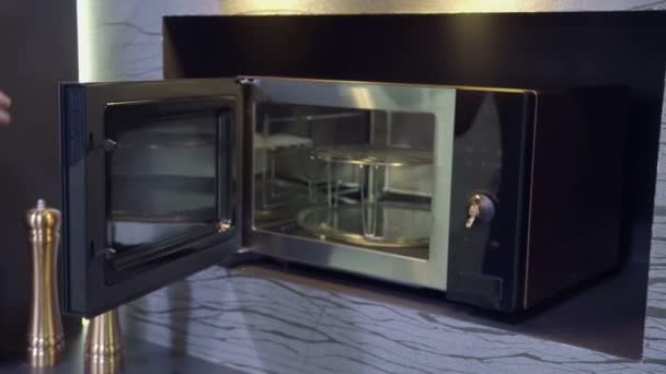 Open microwave in kitchen store — Stock Video