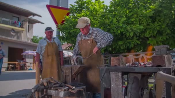 Smith está forjando hierro en una feria rústica — Vídeos de Stock
