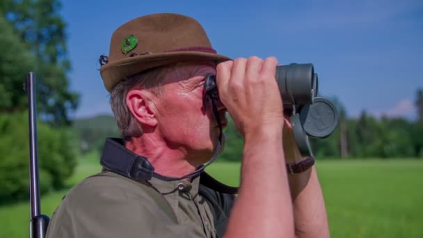 Охотник смотрит на окружающих в зеленом одеянии — стоковое видео