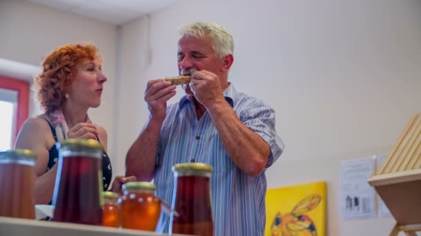Человек ест хлеб с органической медою — стоковое видео
