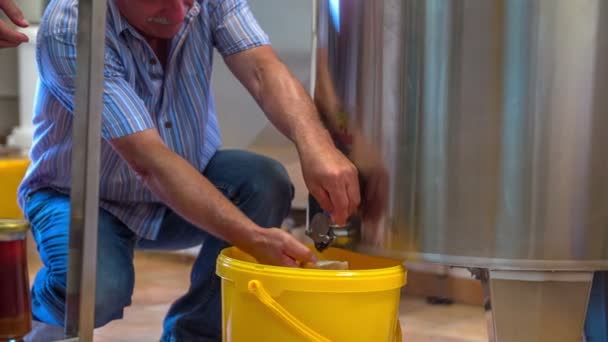 El hombre está recibiendo miel de un barril — Vídeos de Stock