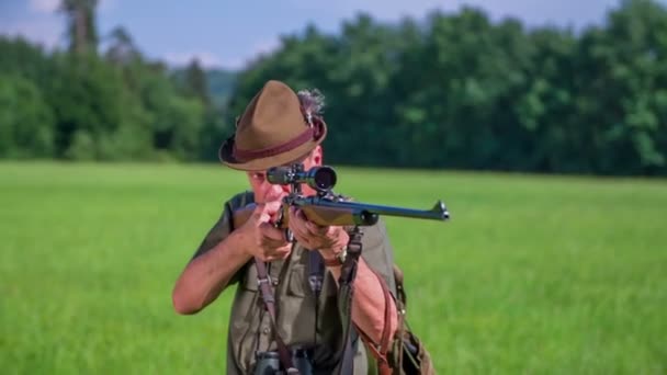 Jäger ist in der Position, auf einem grünen Rasen zu schießen — Stockvideo