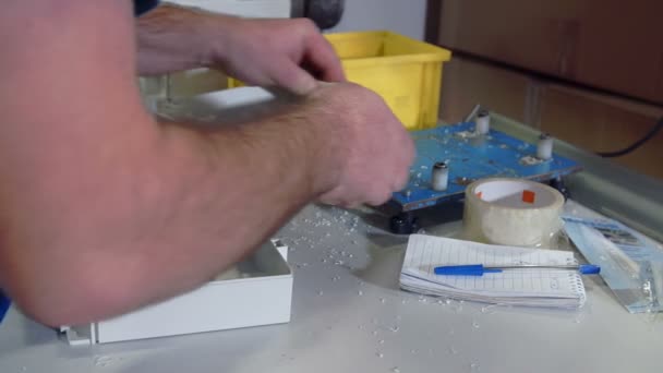 Hombre está construyendo pequeños pedazos de plásticos — Vídeo de stock