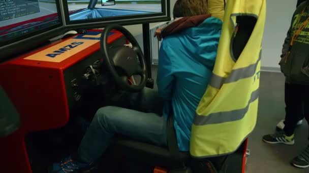 Pojke som rider på auto simulator — Stockvideo