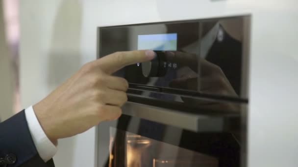 Um homem inspeciona equipamentos na loja de cozinha — Vídeo de Stock