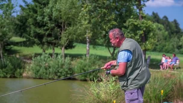 Pesca de Fisher en la costa del estanque — Vídeo de stock