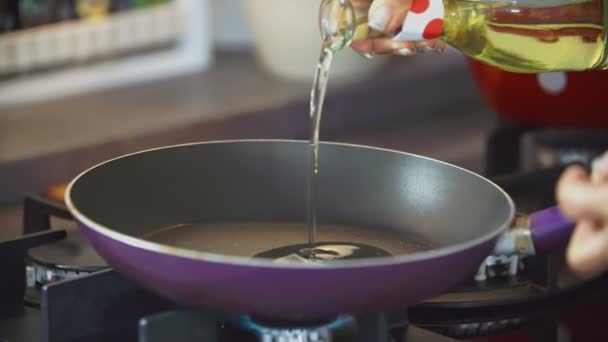 Cocina vertiendo aceite en la sartén — Vídeo de stock
