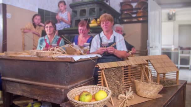 Дети и пожилые женщины плетут солому — стоковое видео