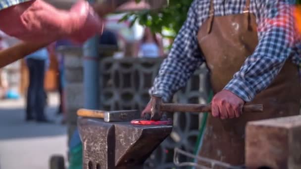 Batendo o ferro quente com um martelo na feira rústica — Vídeo de Stock