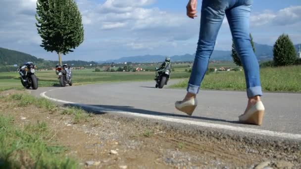 Een jonge vrouw loopt op haar motorfiets — Stockvideo