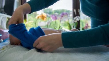 varlık giyinmiş ve annesi tarafından beslenen bebek