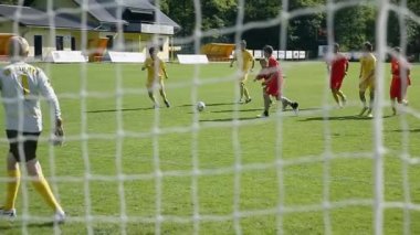 Yeşil sahada futbol oynayan gençler