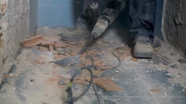 İşçi banyo karoları ile elektrikli matkap kaldırmak için çalışıyor