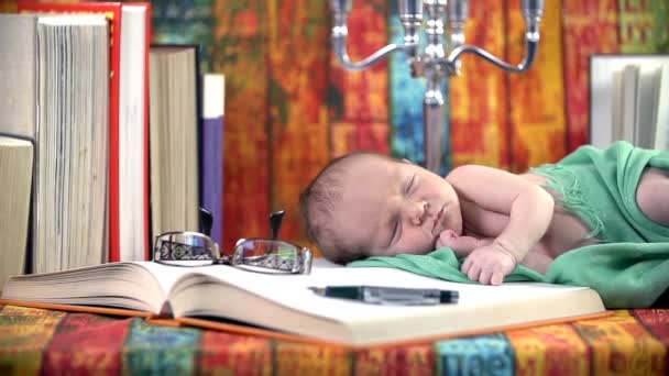 Baby slapen op een boek — Stockvideo