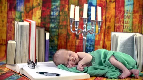 Baby schläft auf einem Buch — Stockvideo