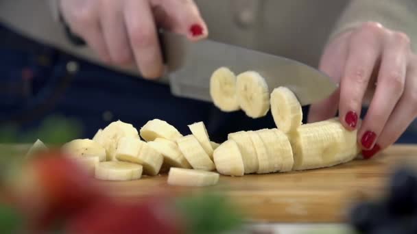 Vrouw snijden van de banaan — Stockvideo