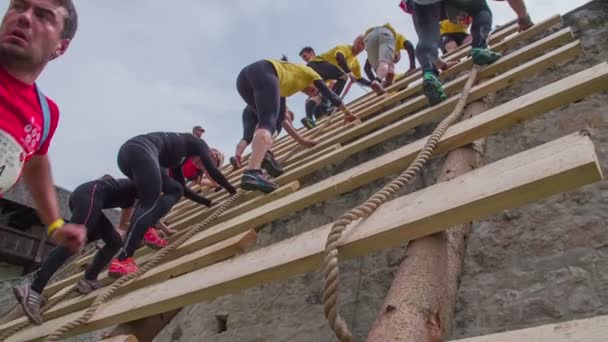 Personas corriendo a través de la carrera de obstáculos y subir por la escalera — Vídeo de stock