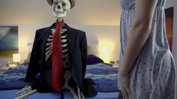 Woman sitting by skeleton — Stock Video