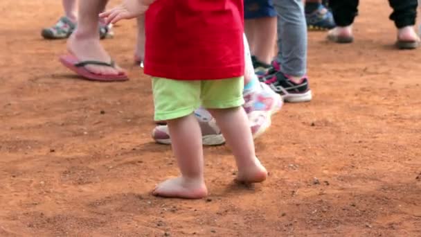 Child barefoot walking around with medal hanging — Stock Video