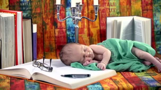 Baby schläft auf einem Buch — Stockvideo