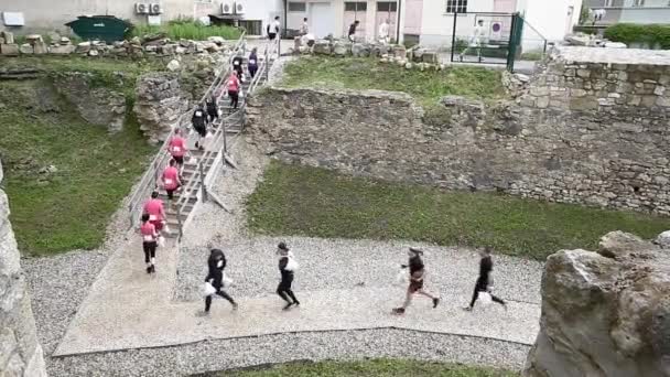 Sportler laufen mit Tüten über Rennstrecke — Stockvideo