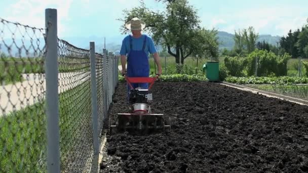 Man som arbetar på egen jordbruksmark — Stockvideo