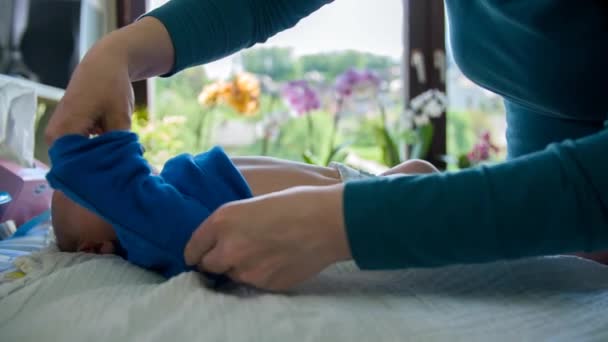 Bebé siendo vestido y nutrido por su madre — Vídeos de Stock