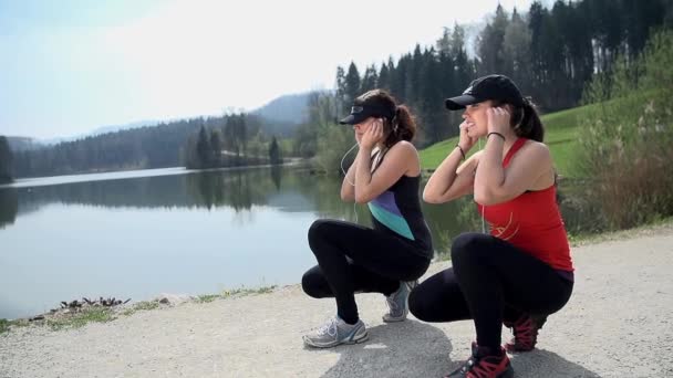 Frauen setzen Kopfhörer auf — Stockvideo