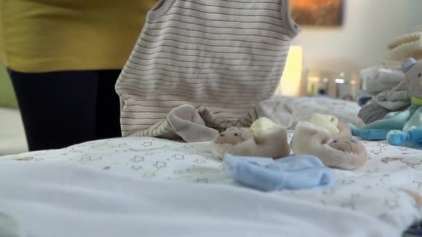 Беременная женщина устраивает одежду — стоковое видео