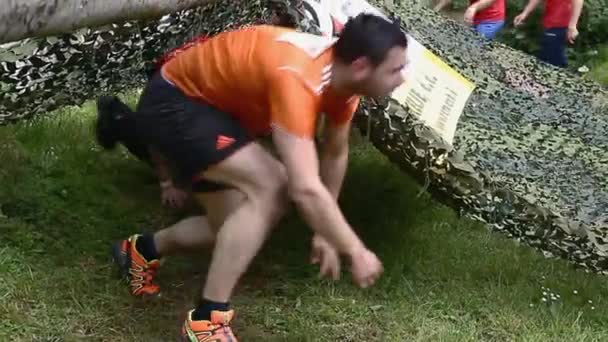 Gente arrastrándose por la carrera de obstáculos — Vídeo de stock