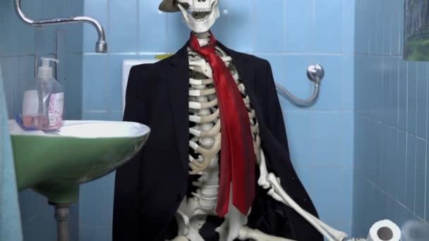 Skeleton is sitting on the toilet — Stock Video