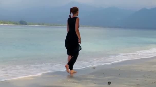 Женщина, идущая по морю — стоковое видео