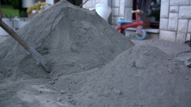 Männer schaufeln Kalk und Sand auf dem Hof — Stockvideo