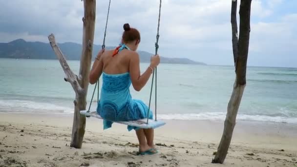 Женщина, качающаяся на берегу моря — стоковое видео